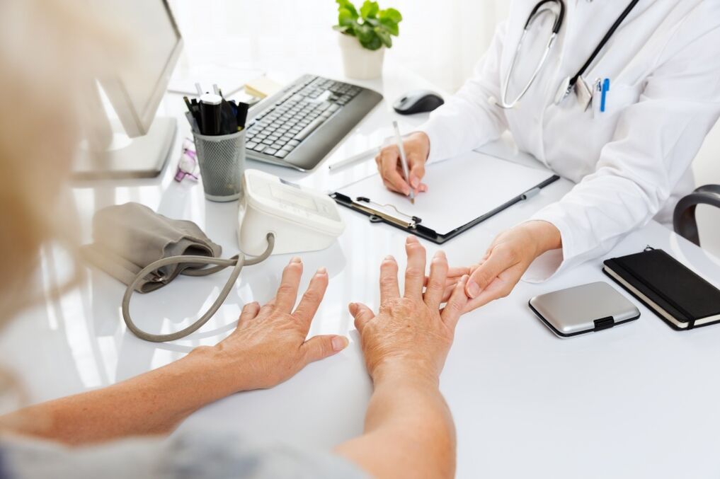 médico examina las manos con artrosis